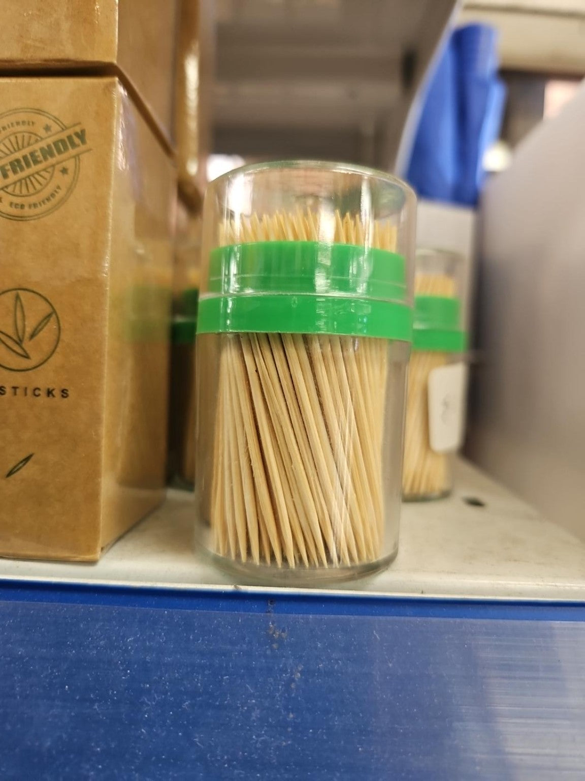 Toothpicks in clear dispenser with green lid